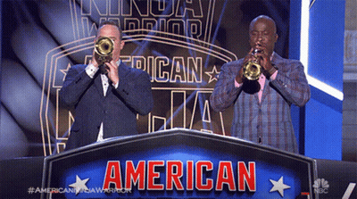 Two Men Are Playing Trumpets In Front Of A Banner That Says American GIF