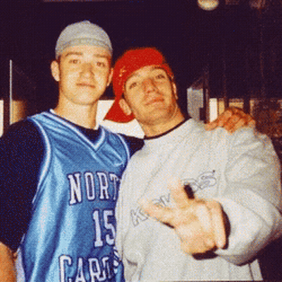 Two Men Are Posing For A Picture And One Is Wearing A North Carolina Jersey GIF