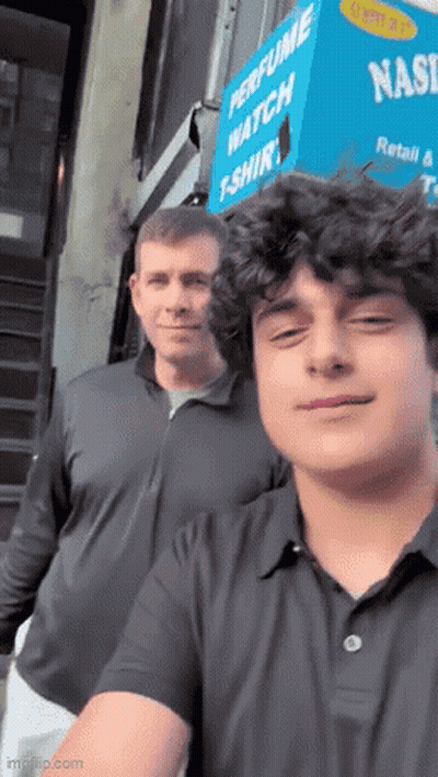 Two Men Are Posing For A Picture In Front Of A Perfume Watch T-Shirt Store GIF