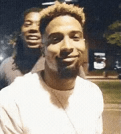 Two Men Are Posing For A Picture Together And One Of Them Is Smiling . GIF