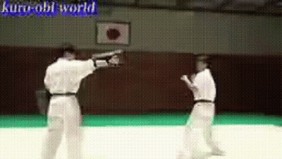 Two Men Are Practicing Martial Arts In A Gym With The Words Kuro-Obi World Written On The Bottom GIF