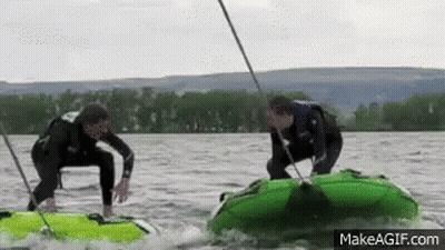 Two Men Are Riding Tubes On A Lake With Makeagif.com At The Bottom Of The Screen GIF
