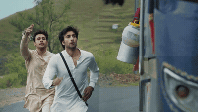 Two Men Are Running Down A Road And One Has A Bag On His Shoulder GIF