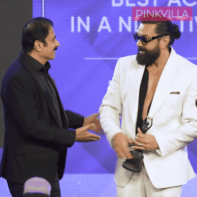 Two Men Are Shaking Hands In Front Of A Pinkvilla Logo GIF