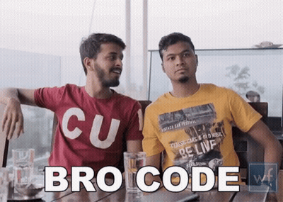 Two Men Are Sitting At A Table And One Of Them Is Wearing A Bro Code Shirt . GIF