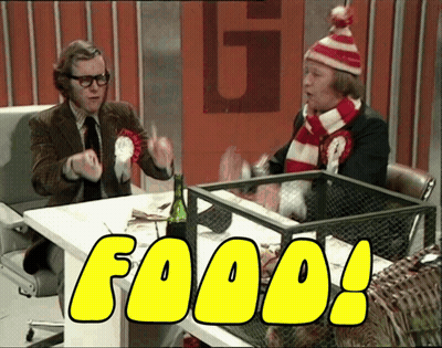 Two Men Are Sitting At A Table And The Word Food Is On The Screen GIF