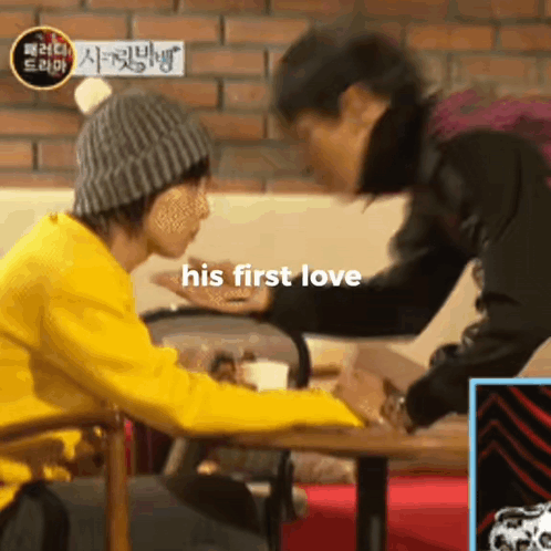Two Men Are Sitting At A Table And The Words His First Love Are On The Bottom GIF