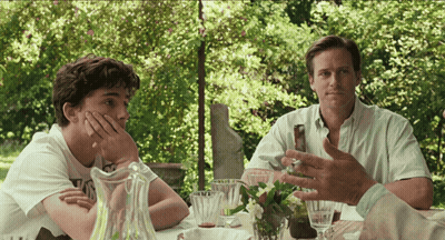 Two Men Are Sitting At A Table With A Pitcher Of Water GIF