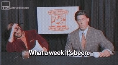 Two Men Are Sitting At A Table With A Sign That Says Southpaw Regional Wrestling GIF