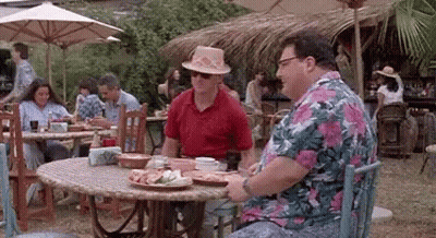 Two Men Are Sitting At A Table With Plates Of Food In Front Of Them . GIF