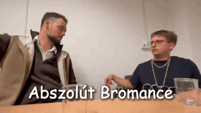Two Men Are Sitting At A Table With The Words Abszolút Bromance Written On The Bottom GIF