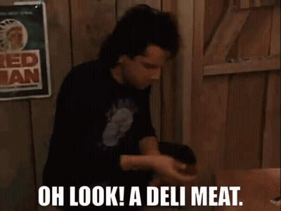 Two Men Are Sitting At A Table With The Words Oh Look A Deli Meat Written On The Screen GIF