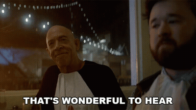 Two Men Are Sitting At A Table With The Words That 'S Wonderful To Hear GIF