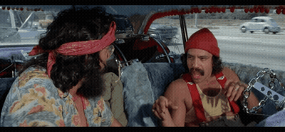 Two Men Are Sitting In A Car And One Has A Bandana On His Head That Says ' Hippie ' On It GIF