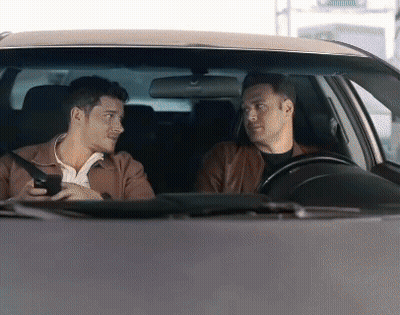 Two Men Are Sitting In A Car And One Is Holding A Cell Phone GIF
