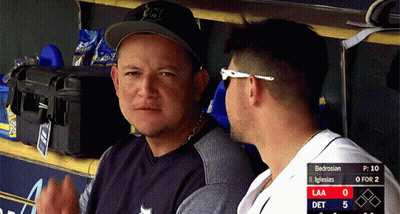 Two Men Are Sitting In A Dugout With A Scoreboard Behind Them That Says Bedrosian On It GIF
