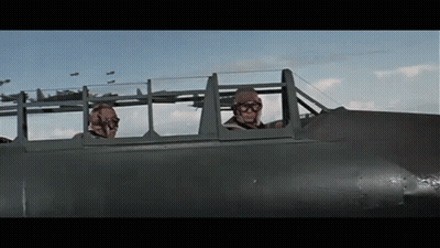 Two Men Are Sitting In A Plane Looking Out The Windows GIF
