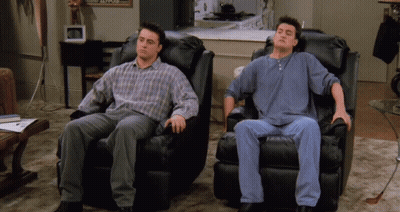 Two Men Are Sitting In Black Leather Chairs With Their Heads Down GIF
