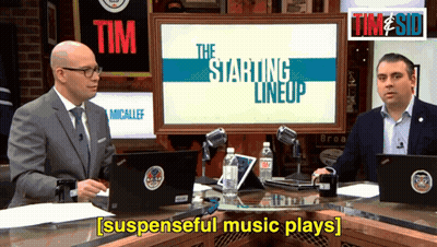 Two Men Are Sitting In Front Of A Screen That Says The Starting Lineup On It GIF