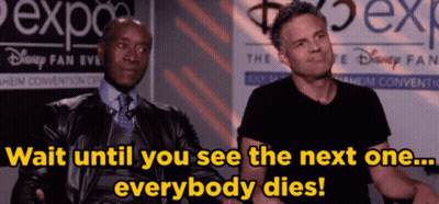 Two Men Are Sitting In Front Of A Sign That Says Disney Fan Event GIF