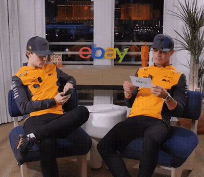 Two Men Are Sitting In Front Of An Ebay Logo GIF