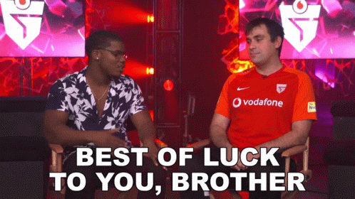 Two Men Are Sitting Next To Each Other And One Is Wearing A Red Vodafone Shirt GIF