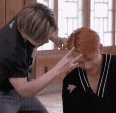 Two Men Are Sitting Next To Each Other And One Of Them Is Touching The Other 'S Head . GIF