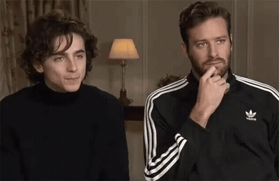 Two Men Are Sitting Next To Each Other In A Room . One Of The Men Is Wearing A Black Adidas Jacket . GIF