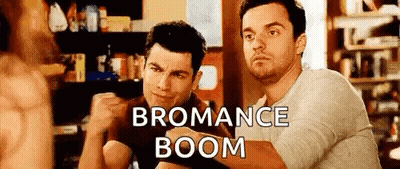 Two Men Are Sitting Next To Each Other In A Room With The Words `` Bromance Boom '' Written On The Bottom . GIF