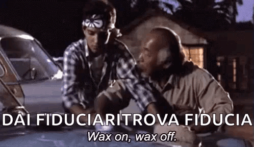 Two Men Are Sitting Next To Each Other In Front Of A Car And Talking . GIF