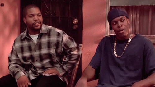 Two Men Are Sitting Next To Each Other In Front Of A Door And Talking GIF