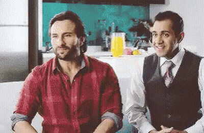 Two Men Are Sitting Next To Each Other On A Couch . GIF