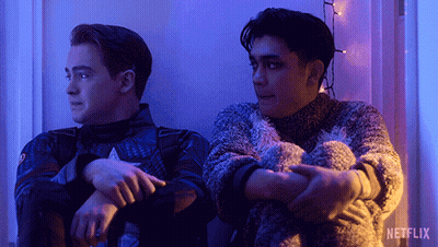 Two Men Are Sitting Next To Each Other With A Netflix Logo In The Background GIF