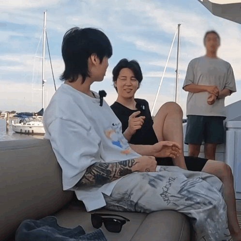 Two Men Are Sitting On A Couch And One Has A Tattoo On His Arm That Says ' I Love You ' GIF