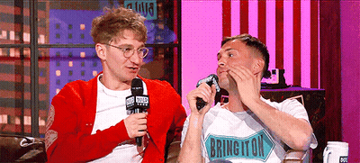 Two Men Are Sitting On A Couch And One Of Them Has A Shirt That Says Brington GIF