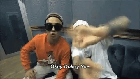Two Men Are Sitting On A Couch And One Of Them Is Wearing Sunglasses And An Orange Shirt . GIF