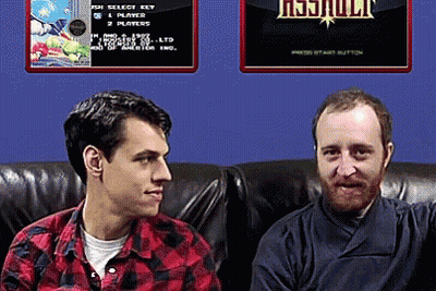 Two Men Are Sitting On A Couch In Front Of A Screen That Says ' Resjuult ' On It GIF