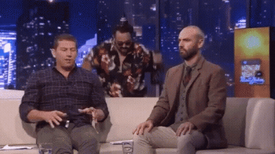 Two Men Are Sitting On A Couch In Front Of A Sign That Says Monday Night GIF