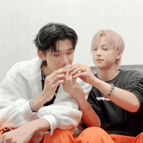 Two Men Are Sitting On A Couch One Wearing A Black Shirt That Says Tmn GIF