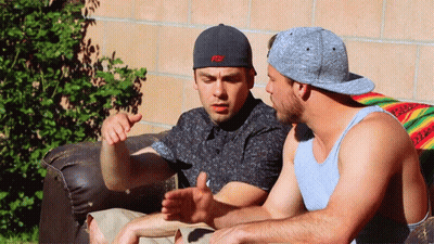 Two Men Are Sitting On A Couch One Wearing A Hat That Says Fox GIF
