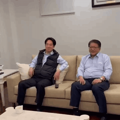 Two Men Are Sitting On A Couch With A Remote Control . GIF