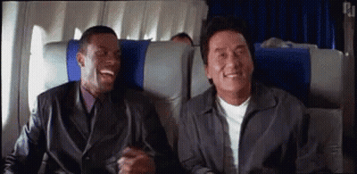 Two Men Are Sitting On A Plane Laughing . GIF
