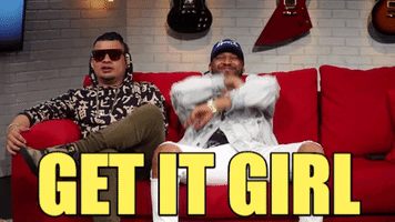 Two Men Are Sitting On A Red Couch With The Words Get It Girl Written In Yellow GIF