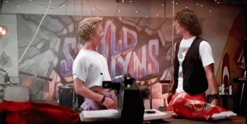Two Men Are Sitting On A Stage In Front Of A Wall That Says Wild Lynns GIF