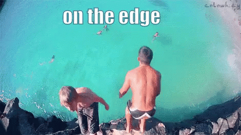 Two Men Are Sitting On The Edge Of A Body Of Water With The Words On The Edge Above Them GIF