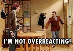 Two Men Are Standing In A Hallway With The Words " I 'M Not Overreacting " On The Bottom GIF
