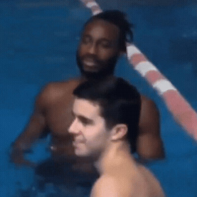 Two Men Are Standing In A Swimming Pool And One Of Them Is Looking At The Camera . GIF