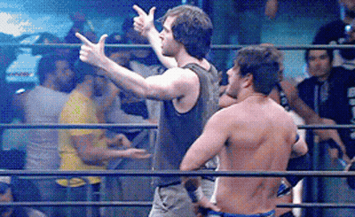 Two Men Are Standing In A Wrestling Ring And One Is Pointing GIF