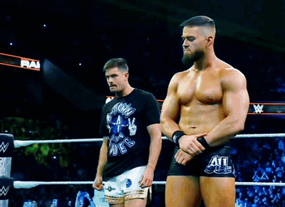 Two Men Are Standing In A Wrestling Ring With One Wearing A Shirt That Says " Storm Rider " On It GIF