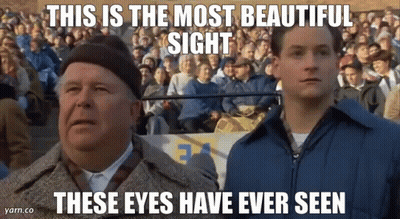 Two Men Are Standing In Front Of A Crowd Of People And Looking Up At The Sky . GIF